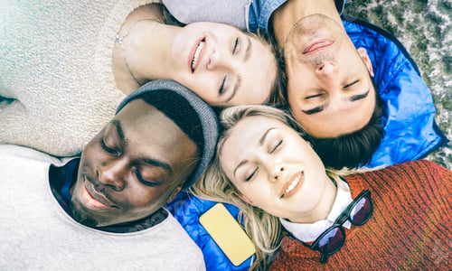 Preview: Top view of multiracial best friends having fun resting together outdoors