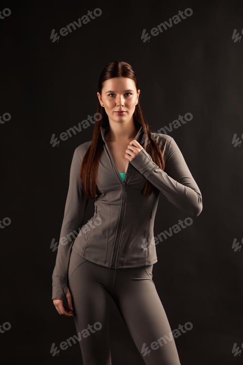 Preview: Alluring Brunette Poses in Activewear Against a Dark Studio Backdrop