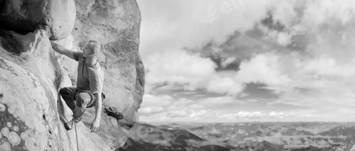 Preview: Male climber climbing big boulder in nature with rope