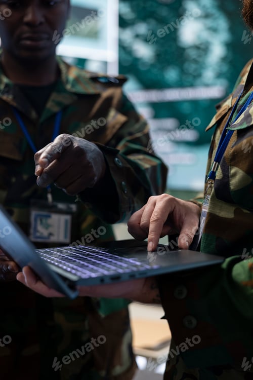 Preview: Diverse army staff collecting real time data on a laptop in control room
