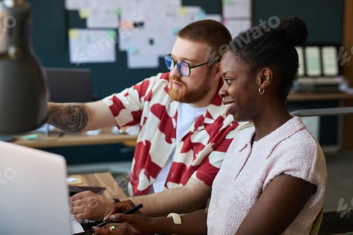 Preview: Young Caucasian Man and Young Black Woman Collaborating on Project in Office