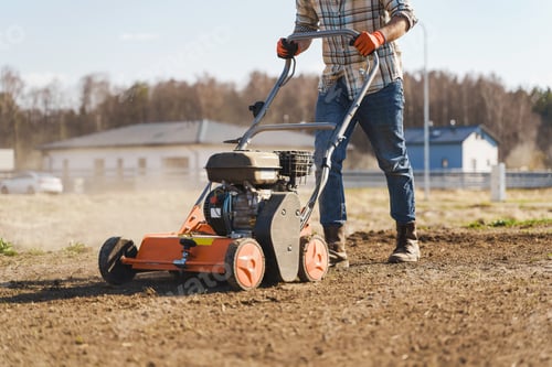 Preview: Man using aerator machine to scarification and aeration of lawn or meadow