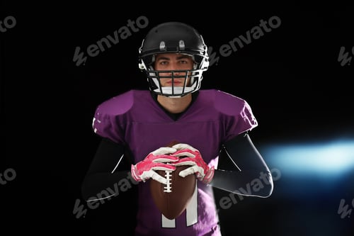 Preview: American football player with ball on dark background