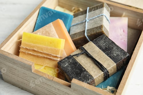 Preview: Different handmade soap bars in wooden box on table, closeup