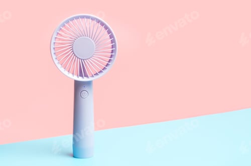 Preview: Small portable mini fans on blue and pink background close-up.
