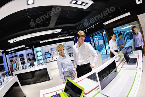 Preview: People In Consumer Electronics Retail Store Looking At Latest Laptop, Television And Photo Camera