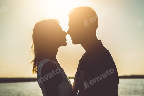 Preview: Romantic couple kissing outside at sunset