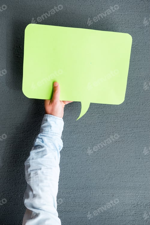 Preview: What can you say? Close-up of man stretching out empty speech bubble against grey background