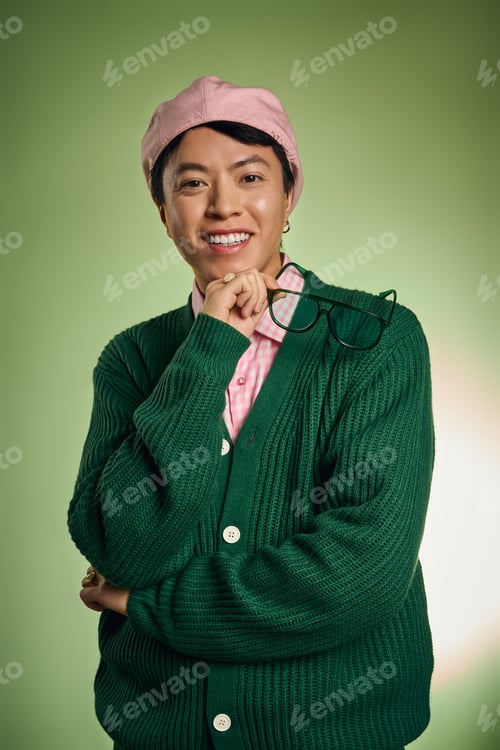 Preview: Stylish asian man brings vibrant charm in pink shirt and green cardigan