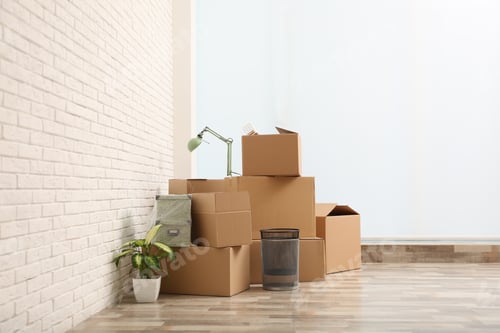 Preview: Moving boxes and stuff near white brick wall in room