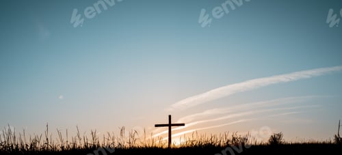 Preview: Wide shot of a hand made a wooden cross in a grassy field with a blue sky in the background