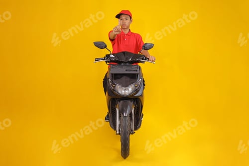 Visualização: Jovem entregador em scooter Signals Stop, pronto para o serviço de encomendas em fundo amarelo brilhante