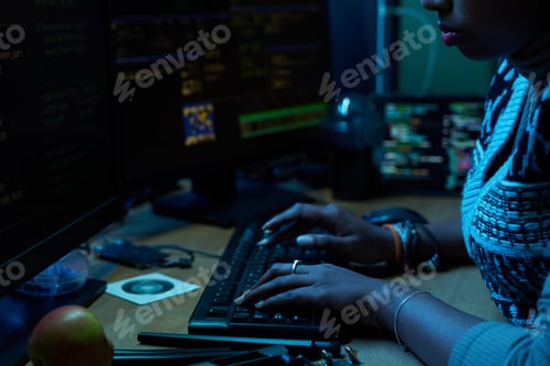 Preview: Young Indian Woman Typing Code on Computer Keyboard in Dark Office