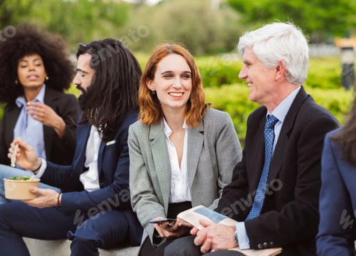 Preview: Co-workers, of different ages senior man talking to young woman at lunch