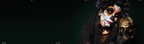 Preview: Woman with mexican day of dead makeup holding skull on dark green background, banner