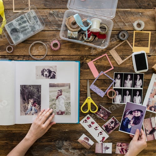Preview: Top view of woman's hands designing photo album