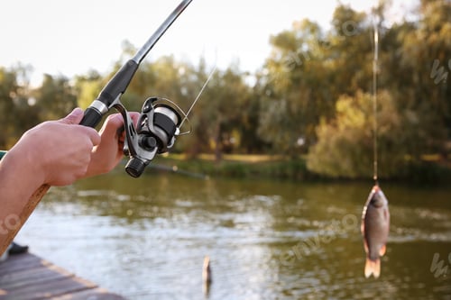 Preview: Man with rod fishing at riverside. Recreational activity