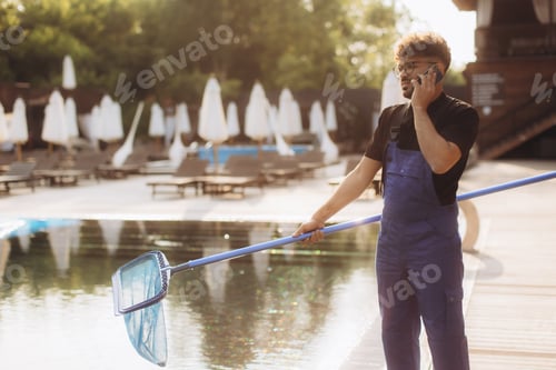Preview: Pool cleaner talking on the phone and holding a landing net