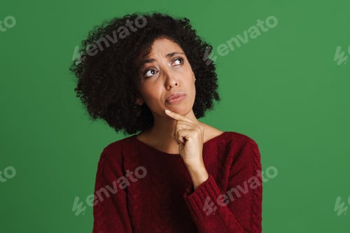 Preview: Black puzzled woman wearing sweater looking aside