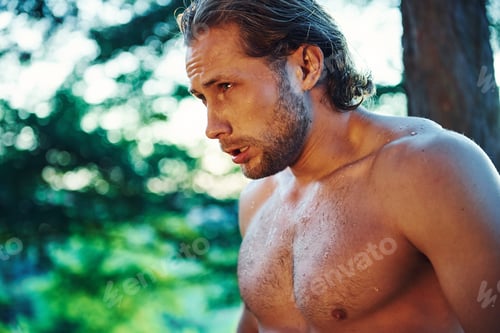 Preview: Handsome shirtless man with muscular body type is in the forest at daytime
