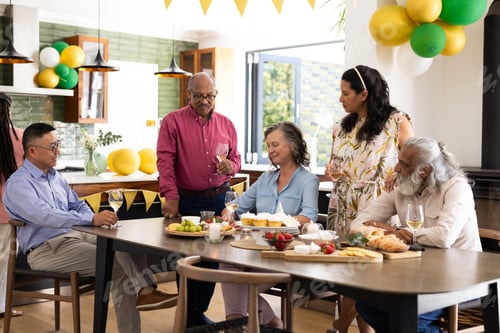 Preview: Seniors enjoying lively conversation and drinks at festive indoor party