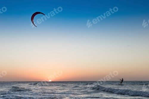 Preview: Kite surfer riding the waves at sunset