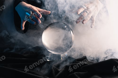 Preview: Cropped view of female hands above crystal ball with smoke on dark