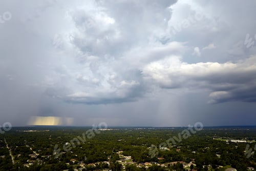 Preview: Dark stormy clouds forming on gloomy sky during heavy rainfall season over suburban town area