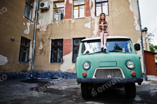 Preview: Amazing long legs with hig heels girl wear on hat sitting on roof of old retro minivan.