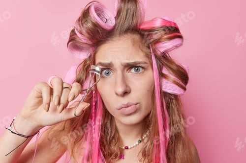 Preview: Young Woman Using Eyelash Curler in Studio