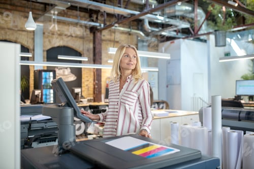 Preview: Blonde woman choosing paper printing settings, looking sideways