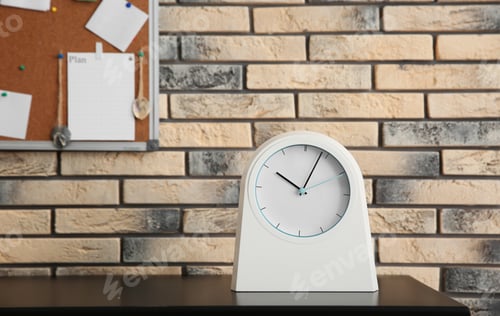 Preview: Stylish clock on table near brick wall. Time management