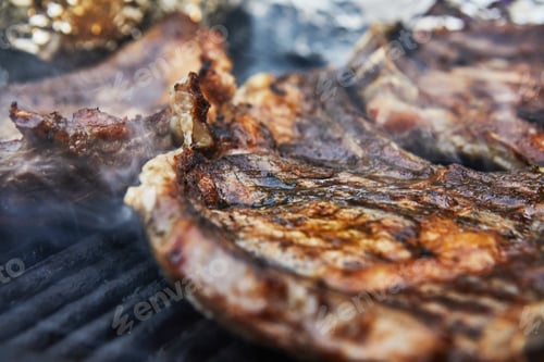 Preview: Grilled beef steaks with grill smoke. BBQ party