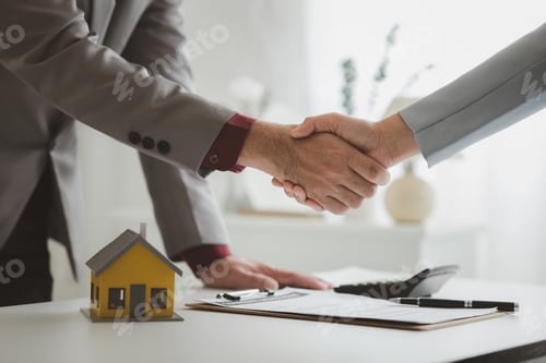 Preview: Housing estate agents shake hands with customers after a deal is completed.