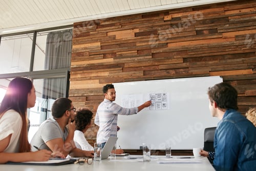 Preview: Young man presenting new app design to colleagues