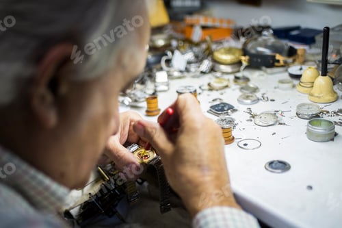 Preview: Watchmaker repairing wristwatch in workshop