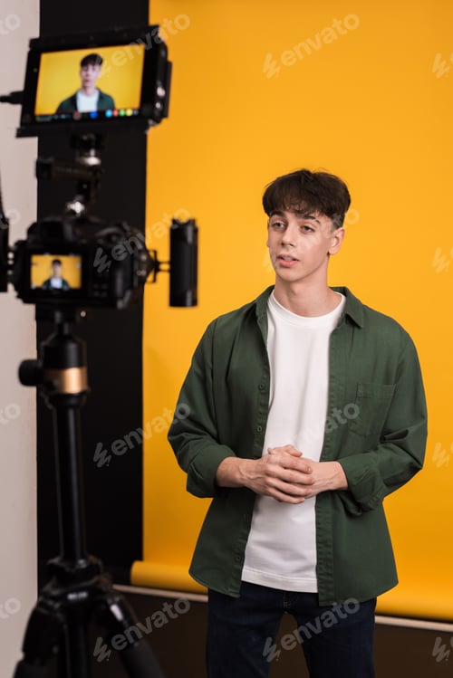 Preview: Professional camera with external display shooting a young man