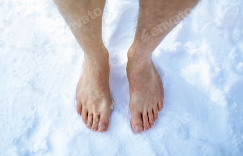 Preview: Top view of male feet standing on snow outdoors, cropped. Unrecognizable guy making cold exposure