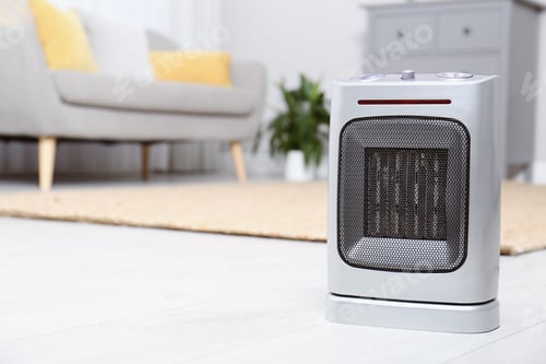 Preview: Modern electric fan heater on floor at home. Space for text