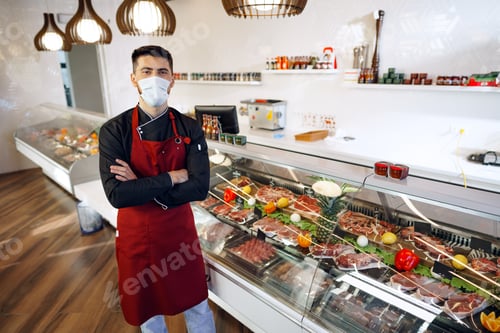 Preview: Portrait of a young man shopkeeper standing by meat stall in supermarket