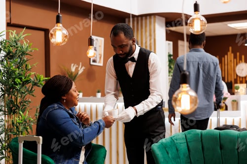 Preview: Hotel waiter serving coffee to woman