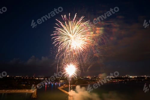 Visualização: Vista aérea de fogos de artifício brilhantes explodindo com luzes coloridas sobre a costa do mar