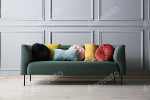 Preview: Stylish sofa with different cushions near grey wall