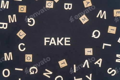 Preview: FAKE word written on dark paper background. FAKE text for your concepts