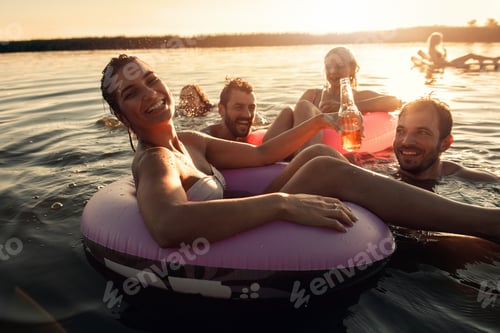Preview: Group of friends enjoying a summer day swimming at the lake.