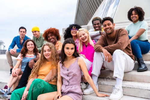 Preview: Happy playful multiethnic group of young friends bonding outdoors