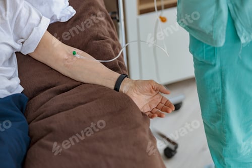 Preview: Nurse putting a drip in the arm of her patient in modern medical clinic
