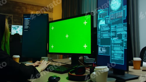 Preview: Zoom in shot of hacker girl in front of computer with green screen