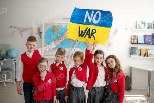 Preview: Little schoolchildren holidng and showing ukrainian flag in classroom, no war concept