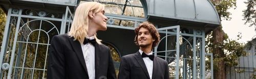 Preview: Young couple enjoying a stylish stroll in elegant tuxedos at a picturesque outdoor location